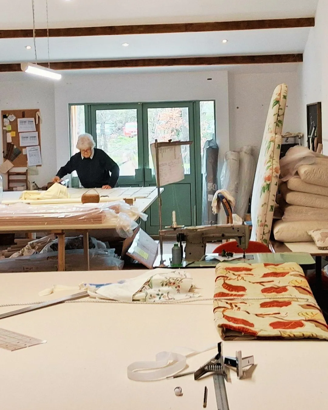 Upholstery craftsman working with fabric at the Savery's workshop in Broadway